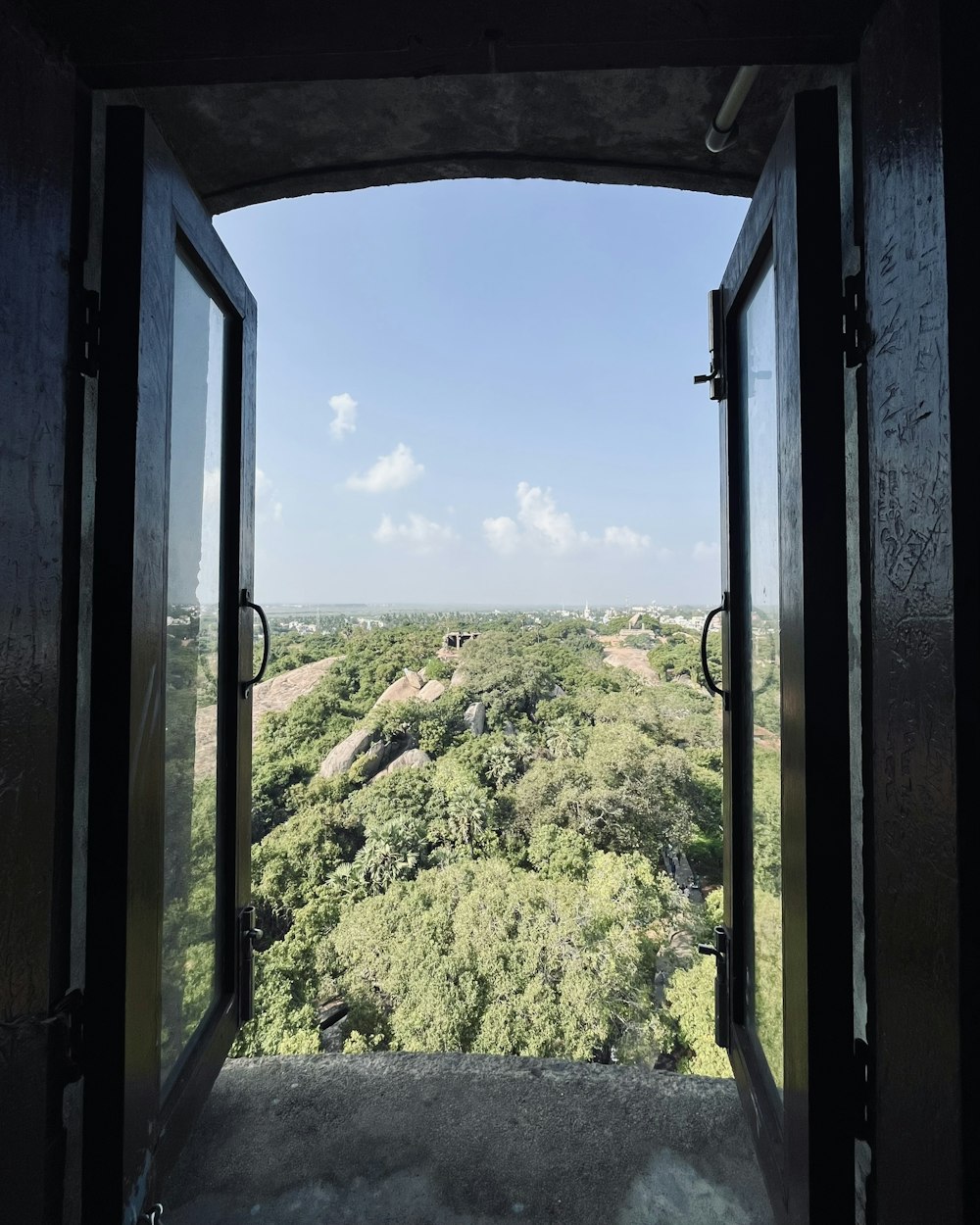 an open door leading to a lush green landscape