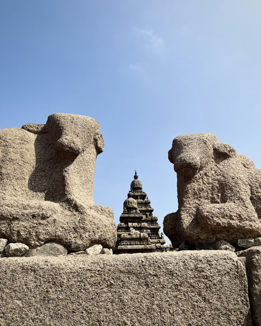 a group of stone sculptures sitting on top of a stone wall