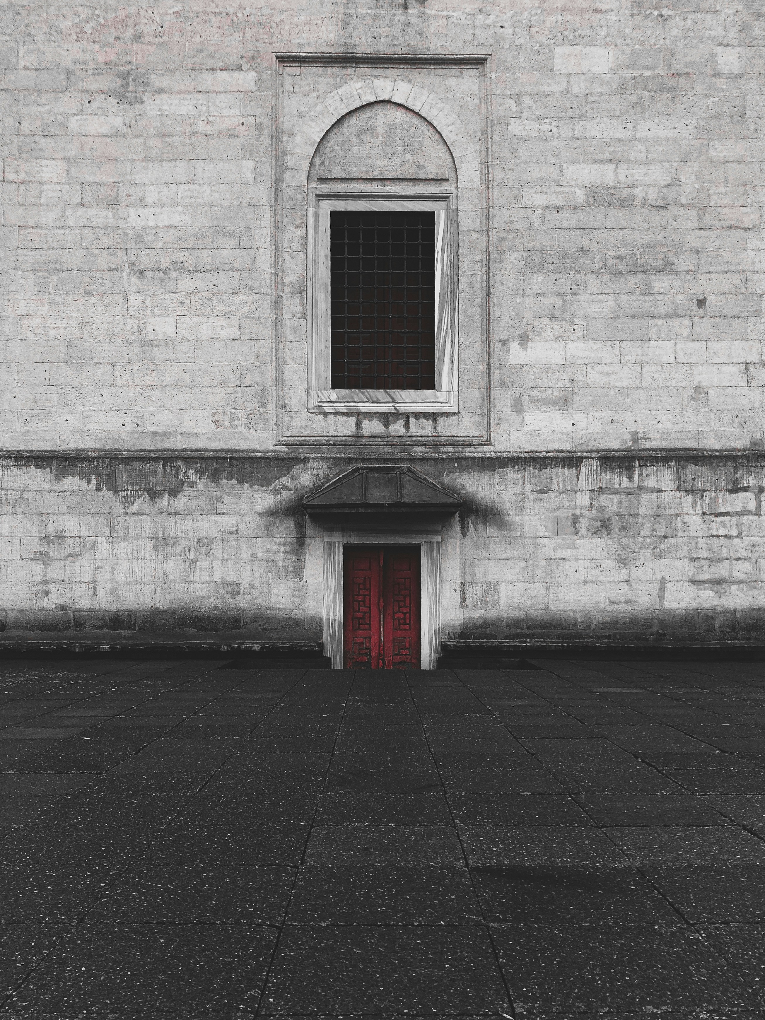 ein Backsteingebäude mit roter Tür und rotem Fenster