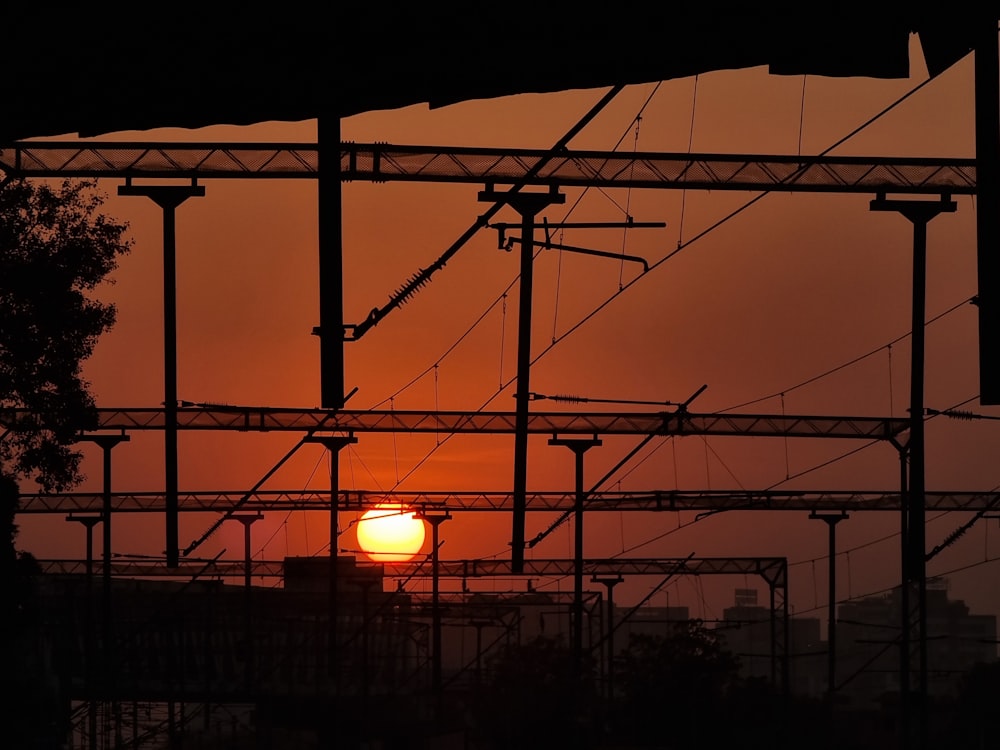 the sun is setting behind a set of train tracks