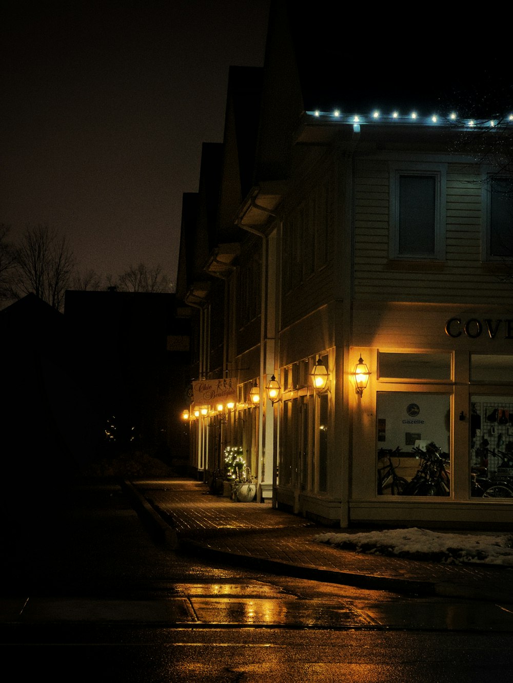 a street at night with a store front lit up