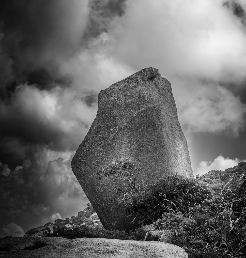 a large rock sitting on top of a lush green field