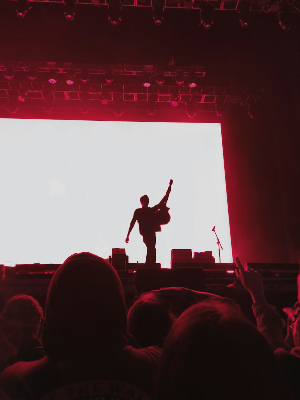 a man standing on a stage with his arms in the air