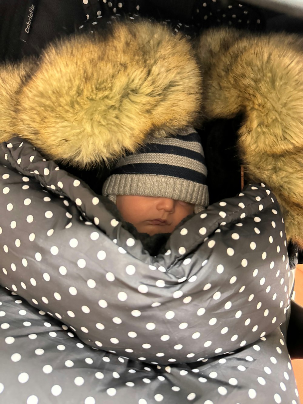 a baby is sleeping in a polka dot blanket