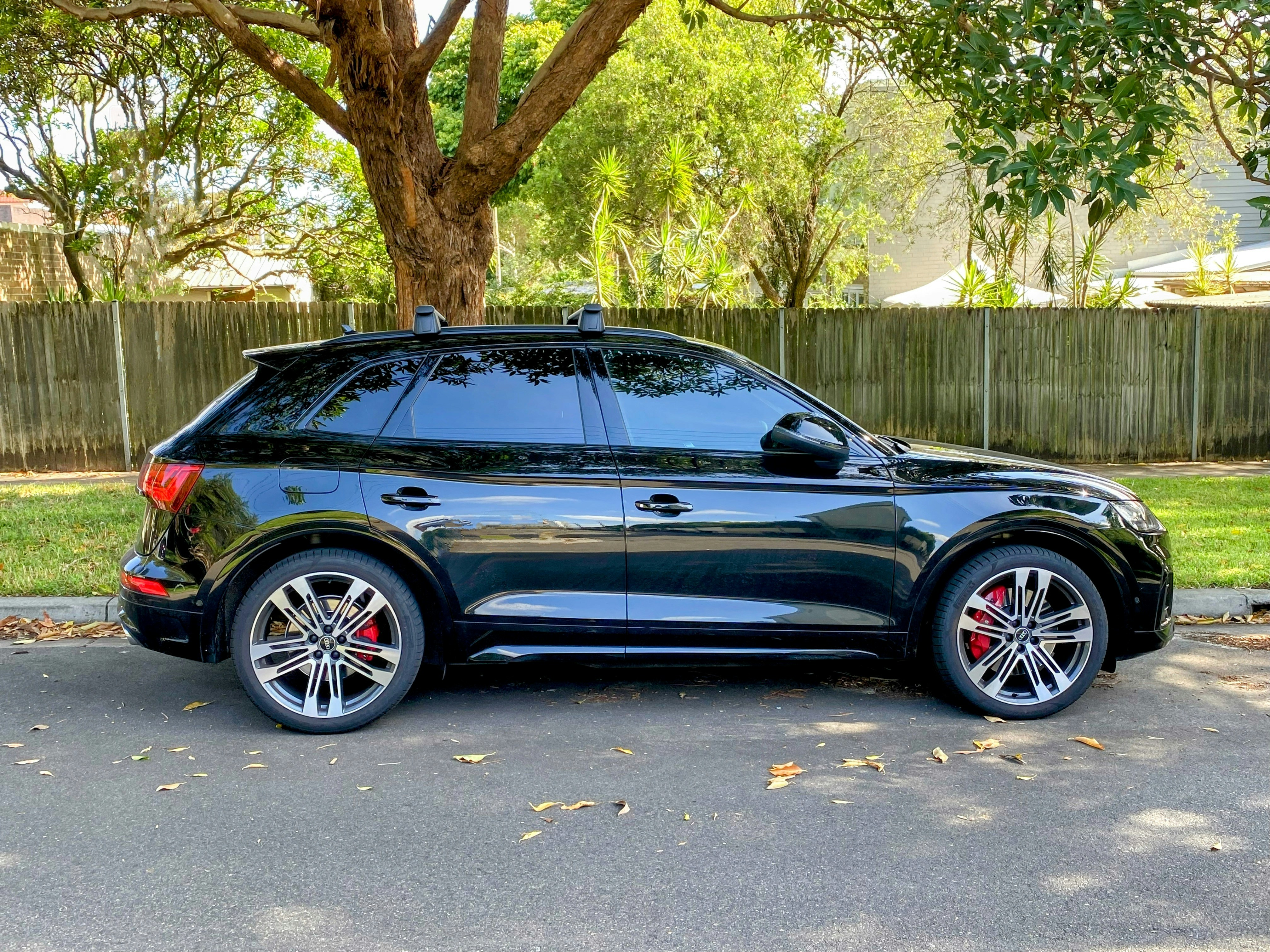 a black suv parked in front of a tree