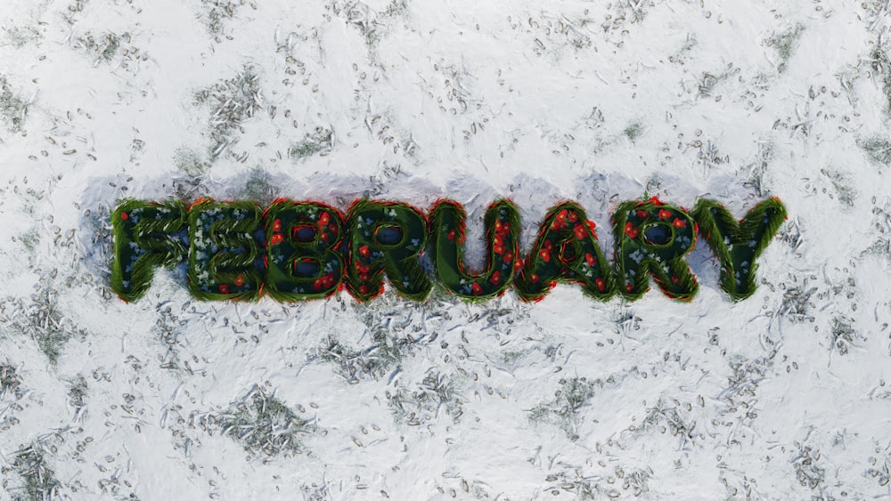 a word written in green and red on top of a snow covered ground