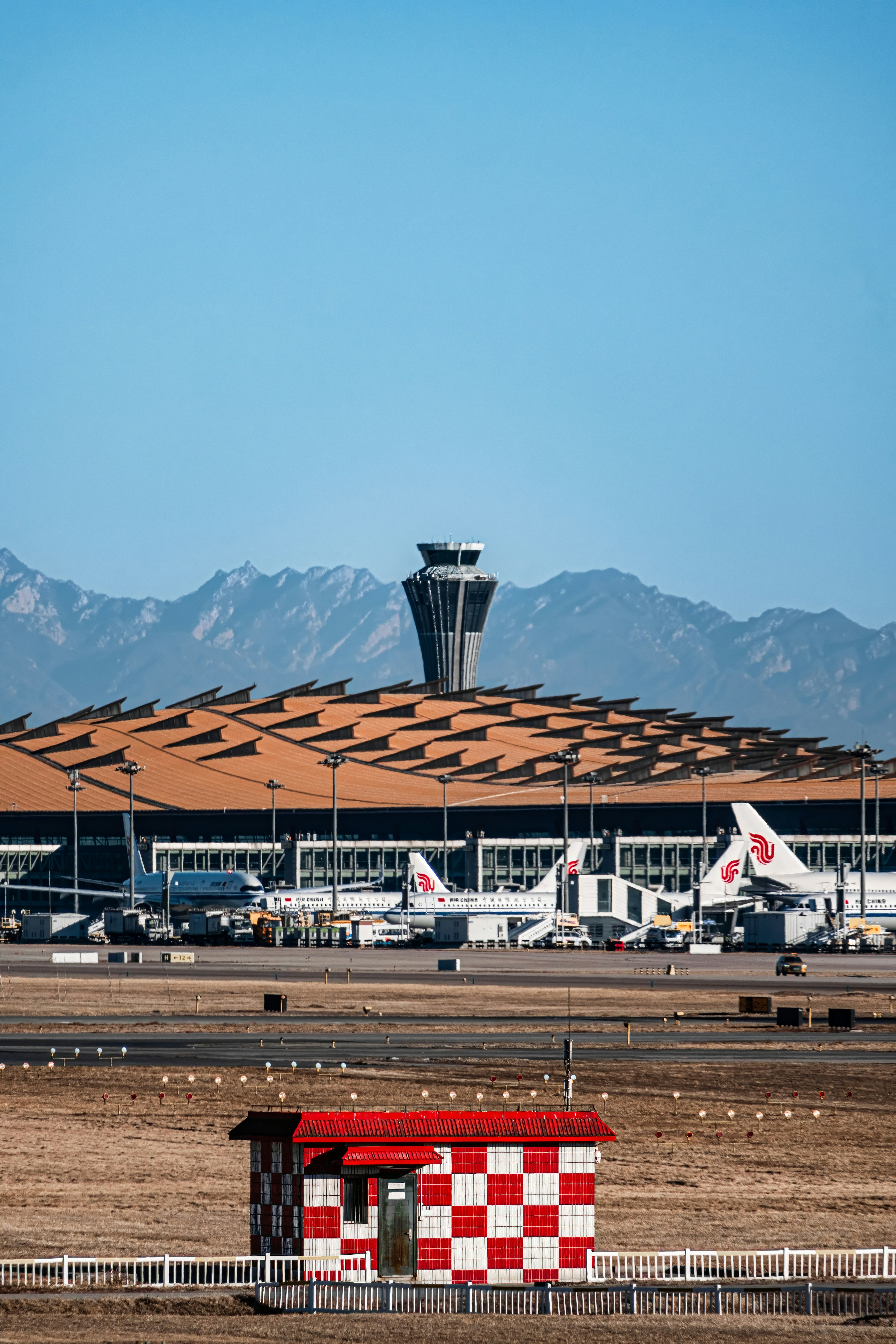 a red and white building sitting on top of an airport tarmac