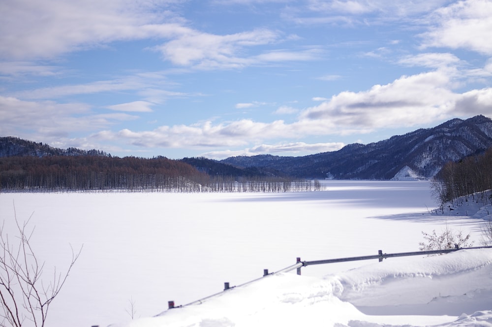 a snowy landscape with mountains in the distance