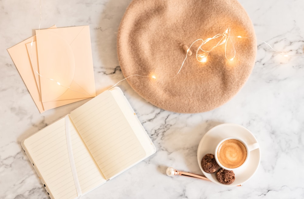 a cup of coffee and a notepad on a marble table