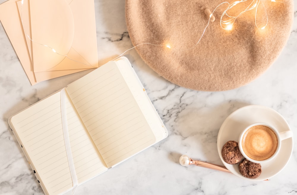 a cup of coffee and a notebook on a marble table