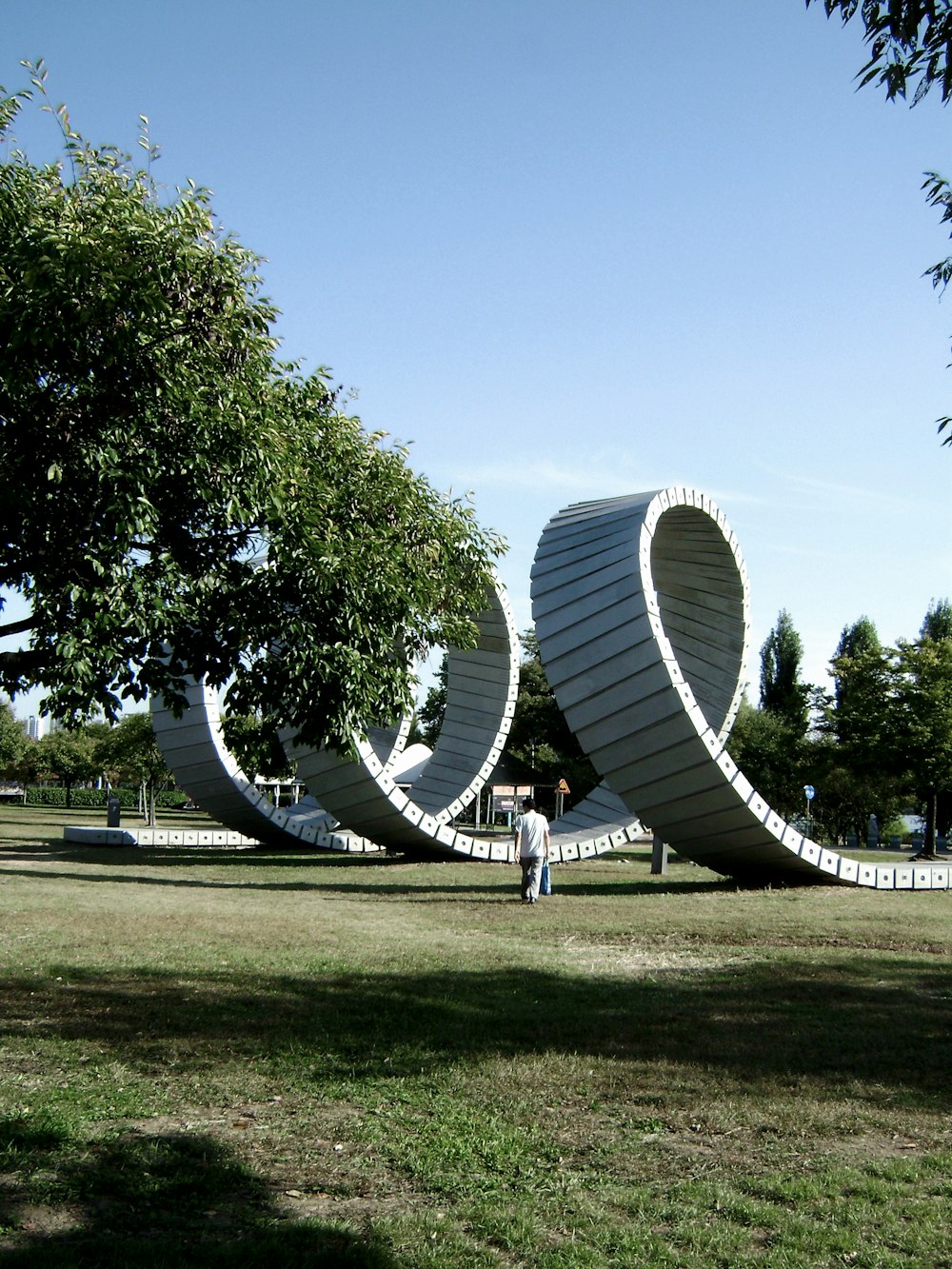 a man standing in front of a sculpture in a park