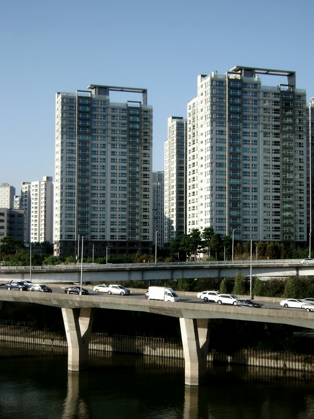 a bridge over a body of water in front of tall buildings