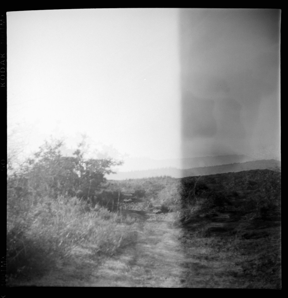 a black and white photo of a dirt road