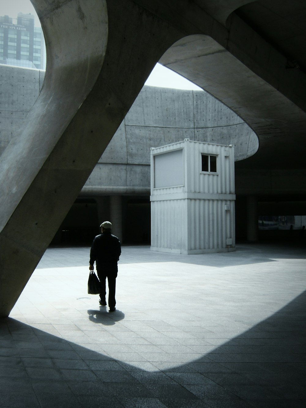 a man in a black jacket is standing in a courtyard