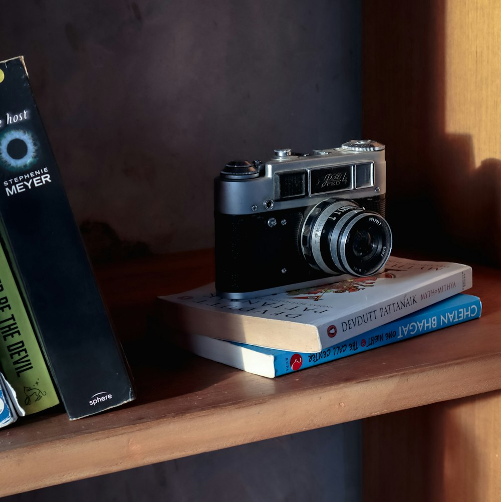 a camera sitting on top of a book on a shelf