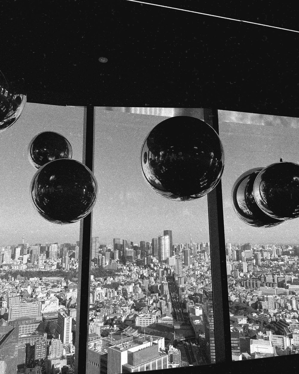 a black and white photo of a window with a view of a city