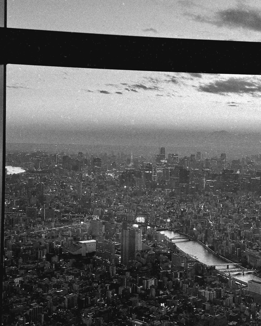 a black and white photo of a city from a window