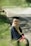 a woman in a graduation gown sitting on the side of a road