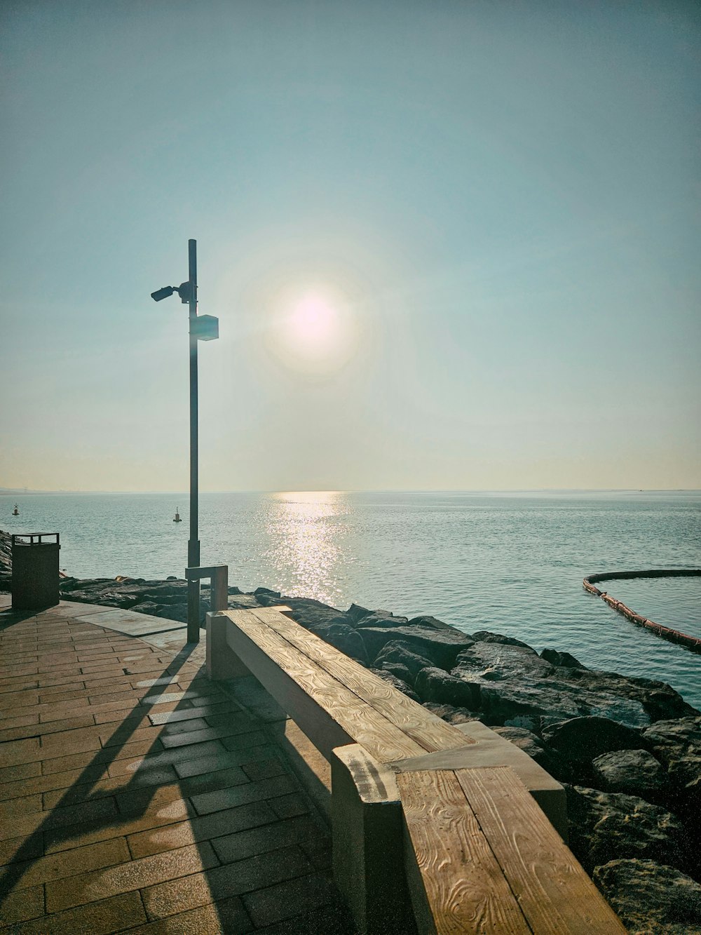 a wooden bench sitting on top of a pier next to the ocean