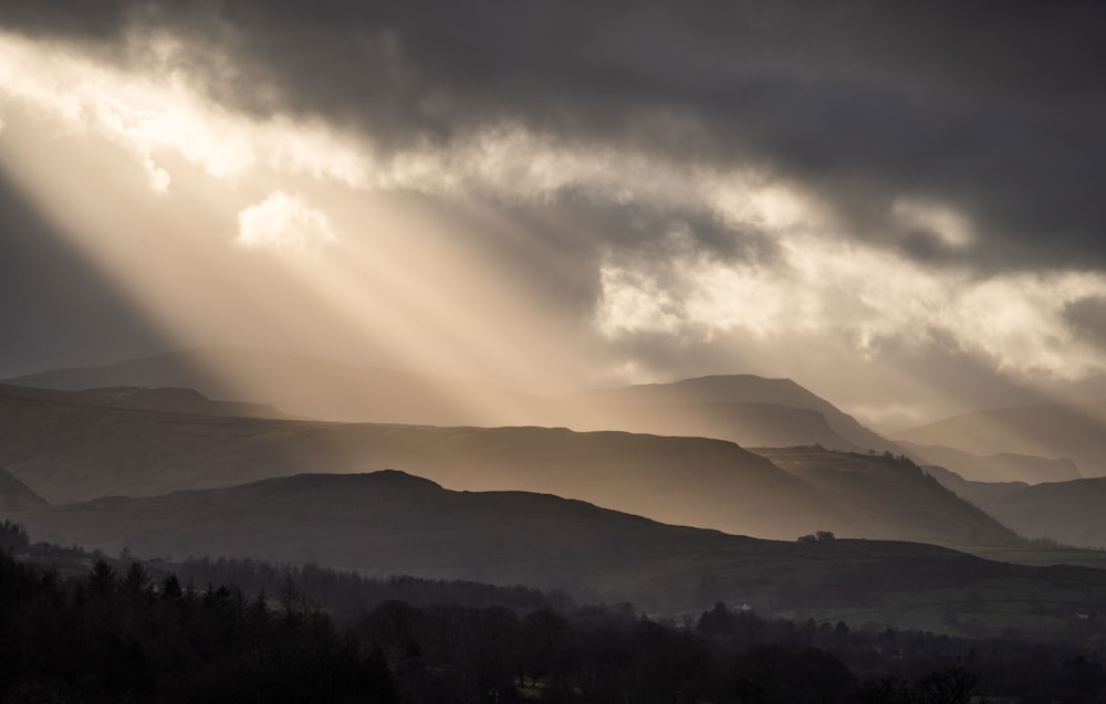 the sun shines through the clouds in the mountains