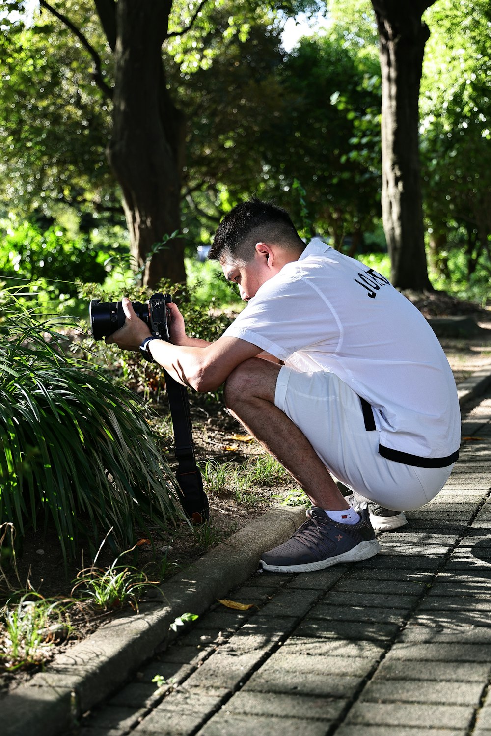 a man kneeling down with a camera in his hand