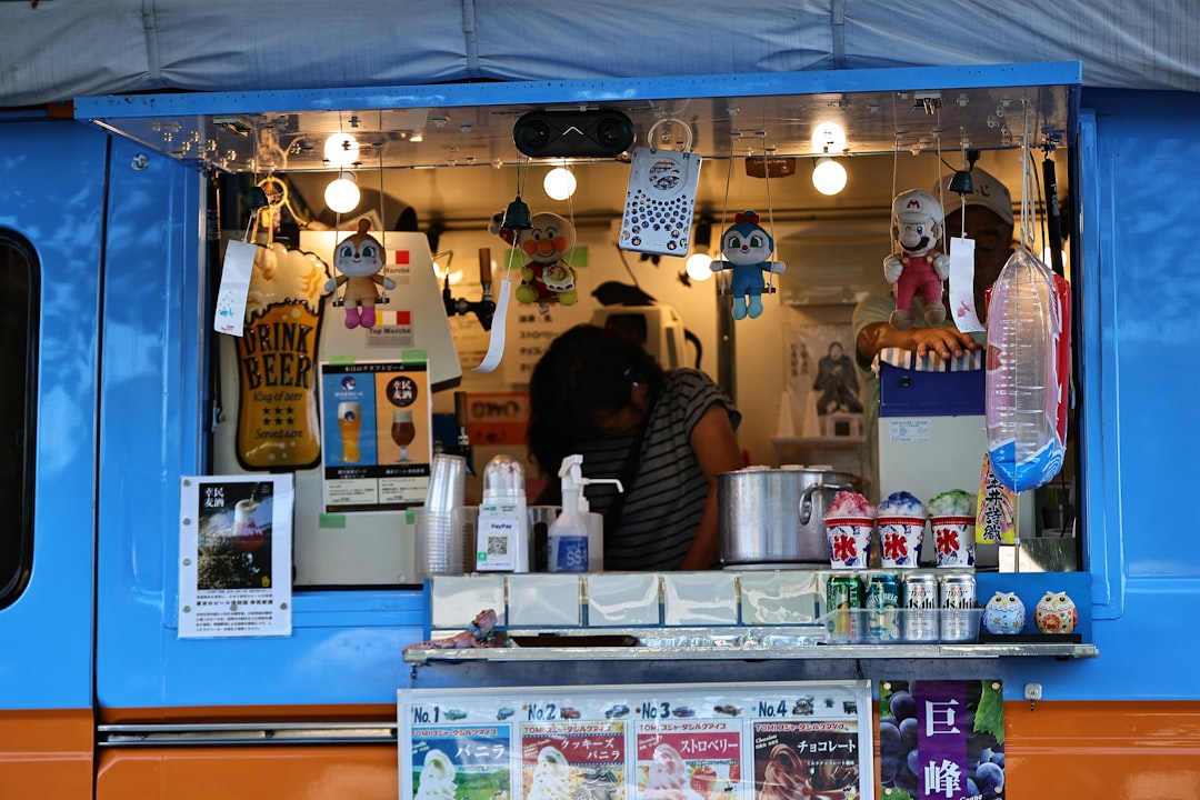 a blue food truck with a man behind the counter,