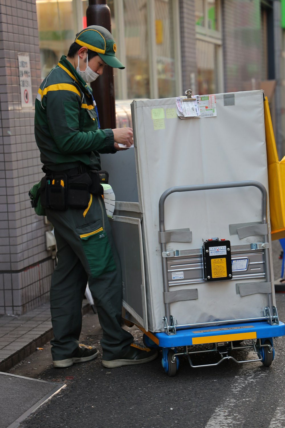 a man standing next to a refrigerator on a city street