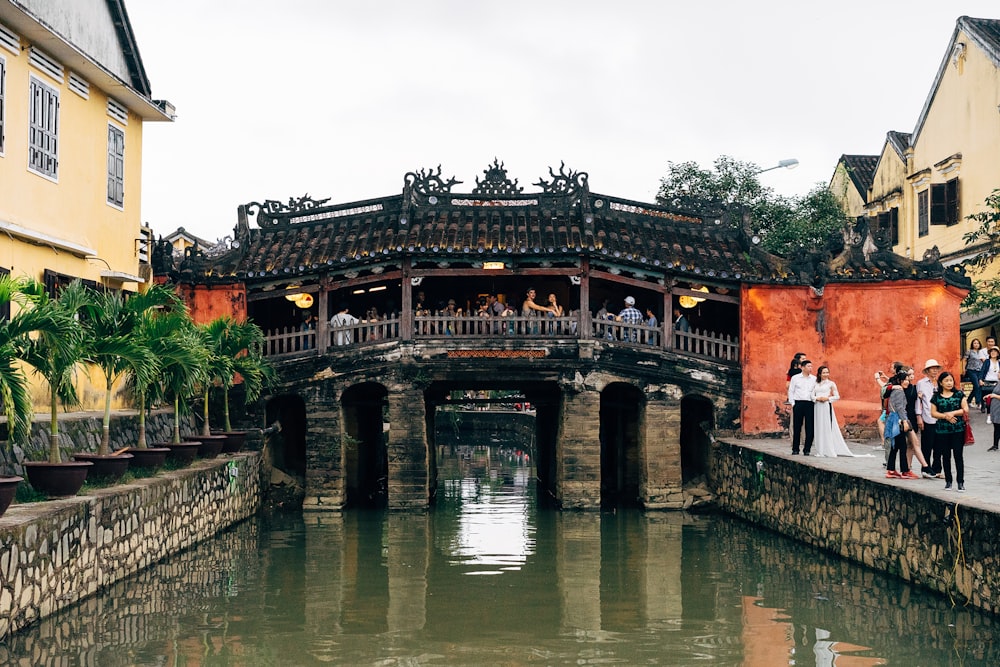 a group of people standing on a bridge over a body of water