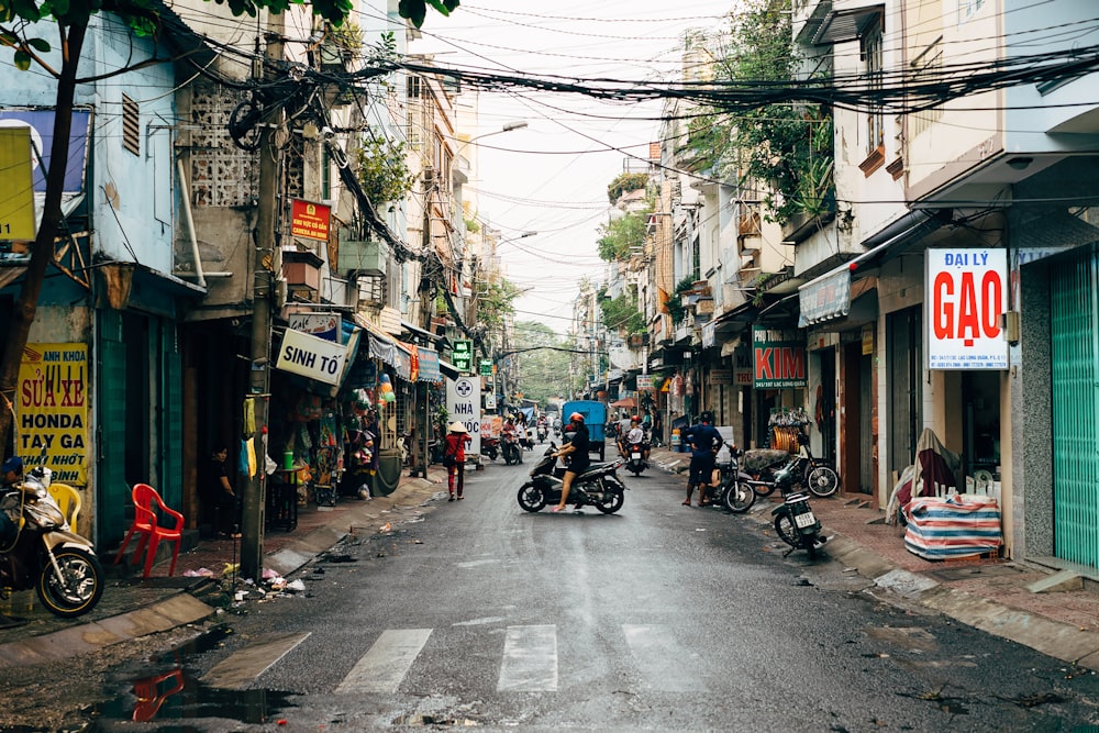 a city street filled with people and parked motorcycles