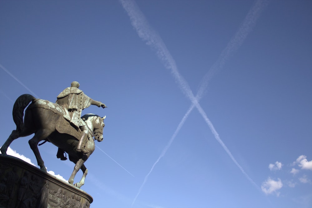 una statua di un uomo su un cavallo con uno sfondo di cielo