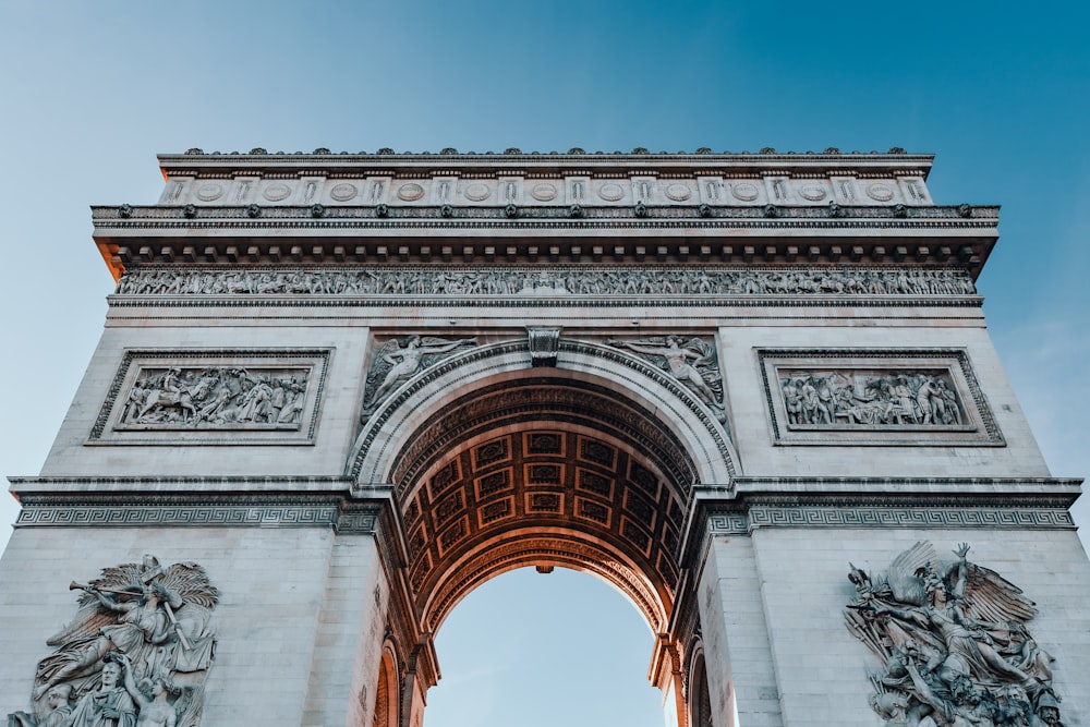 a large white stone arch with statues on it