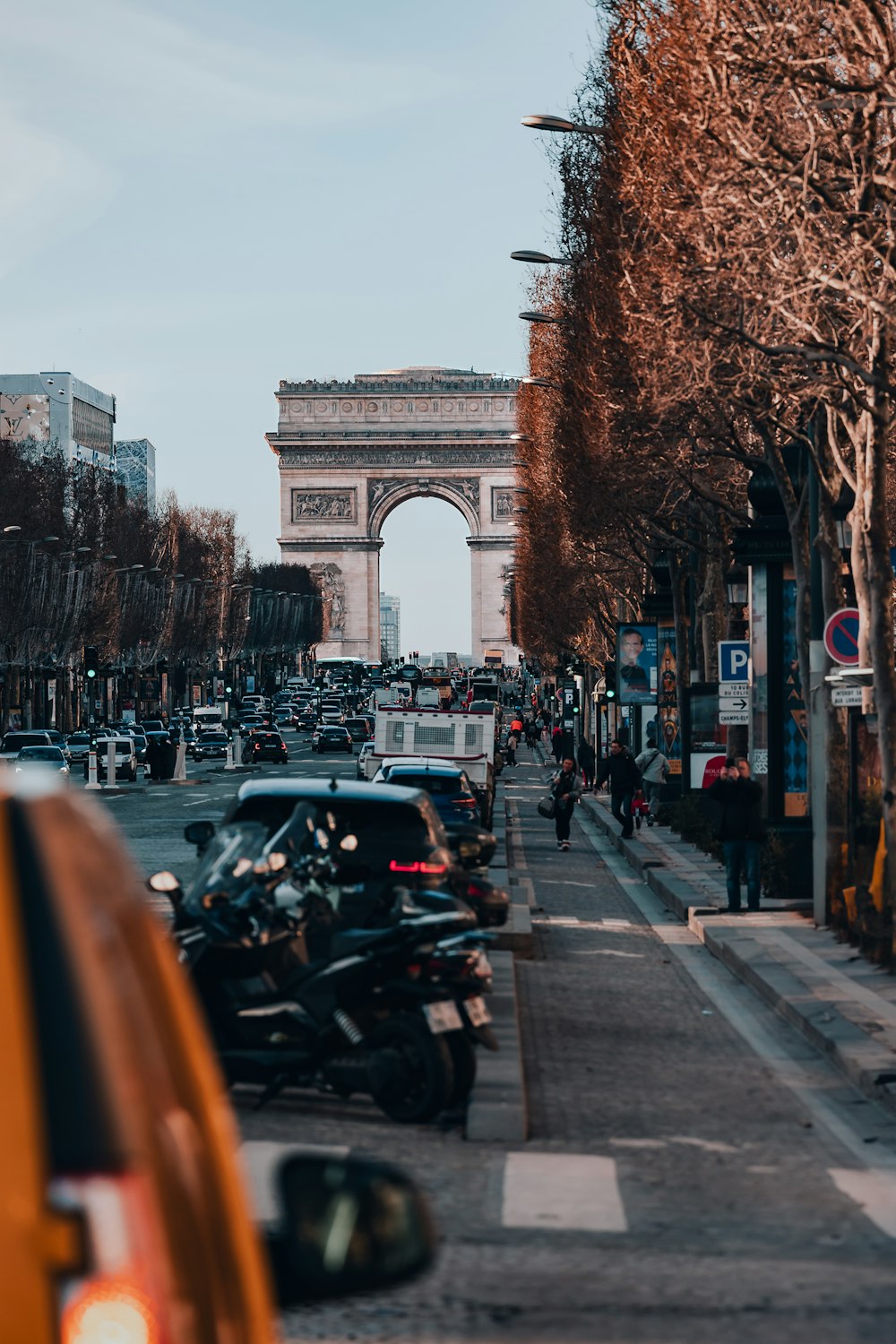 a busy city street with cars parked on the side of the road