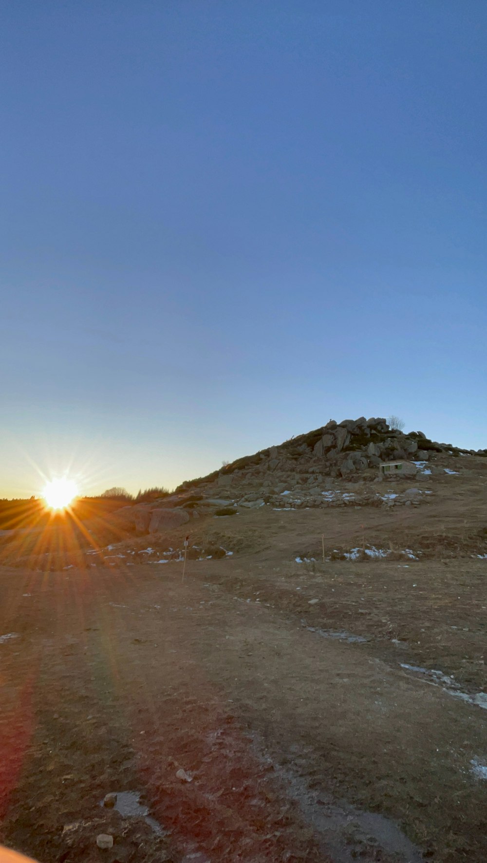 el sol se está poniendo sobre una colina en el desierto