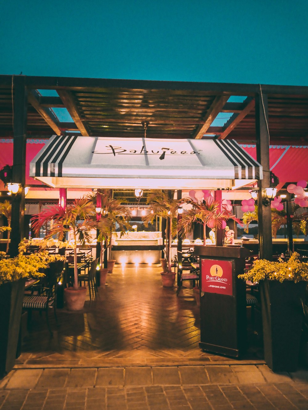 the entrance to a restaurant with potted plants