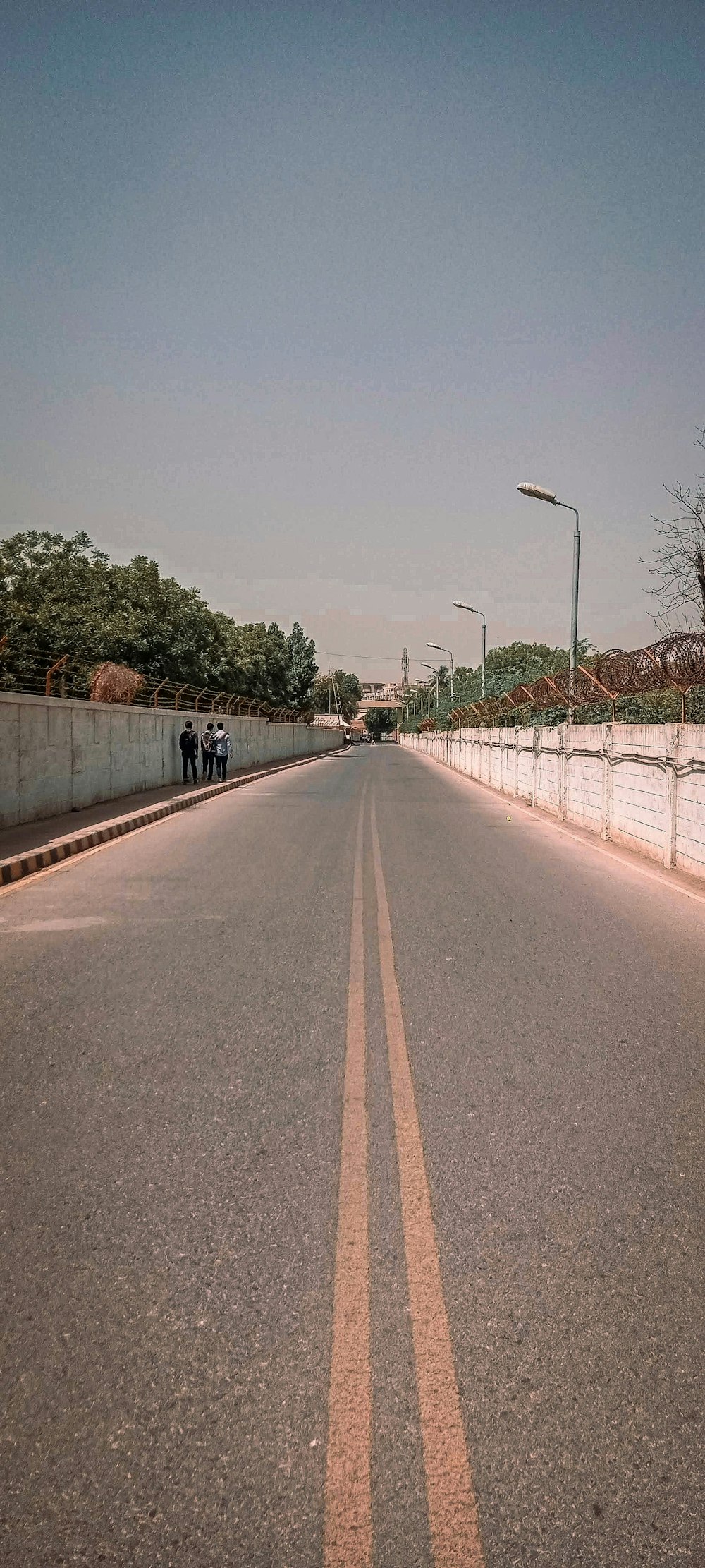 a couple of people standing on the side of a road