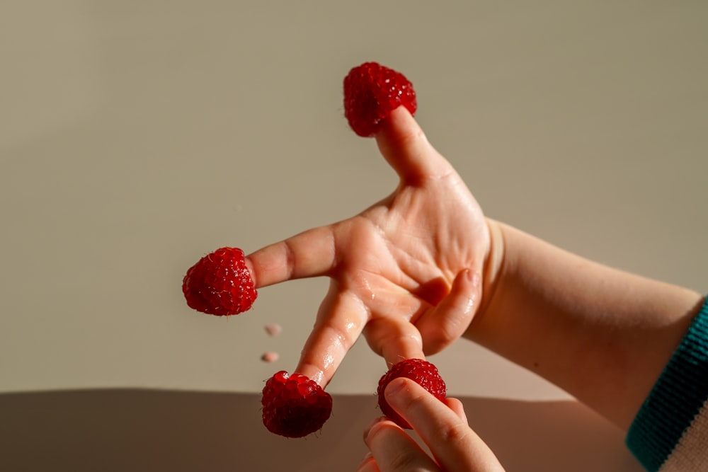 a person holding raspberries in their hands
