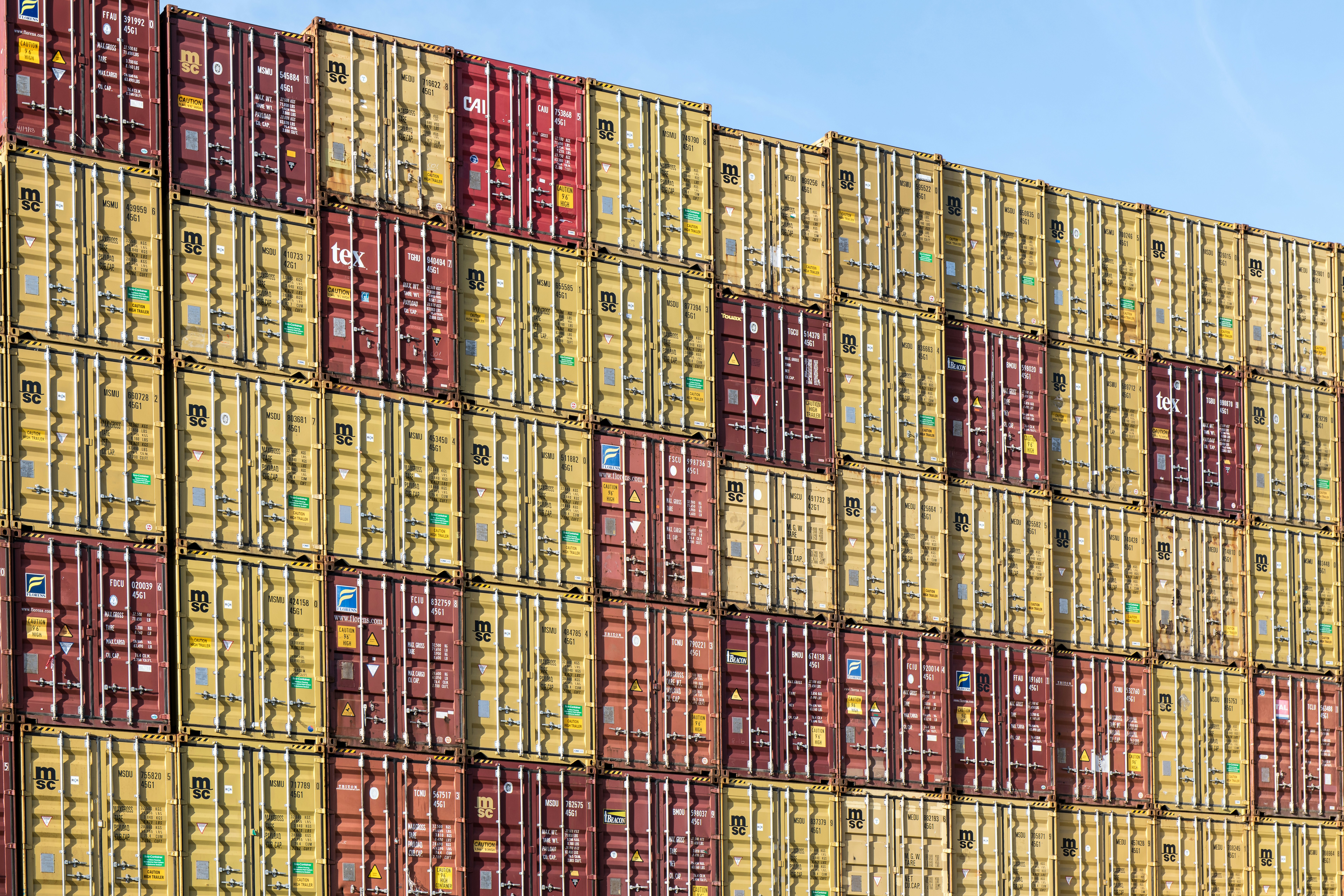 a large stack of yellow and red shipping containers