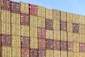 a large stack of yellow and red shipping containers