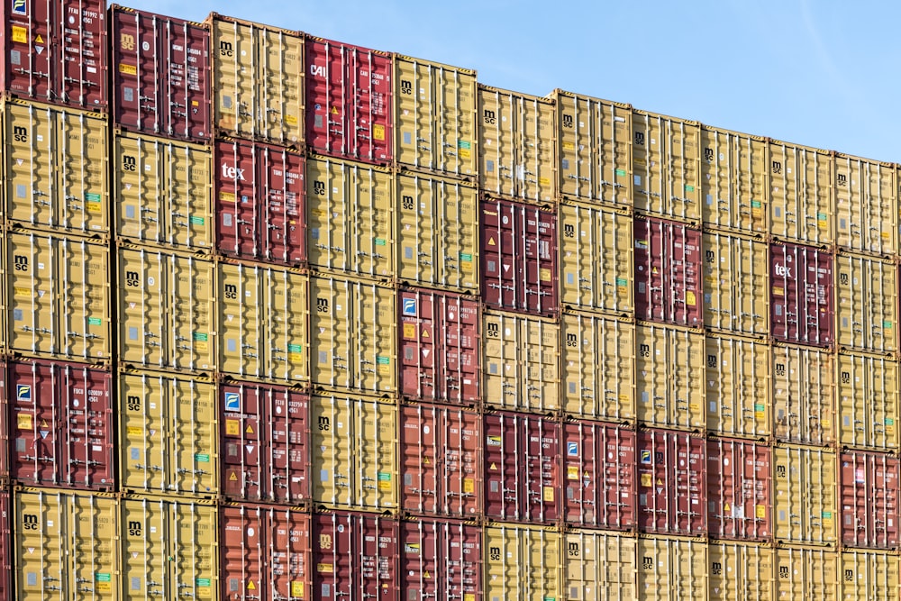 a large stack of yellow and red shipping containers