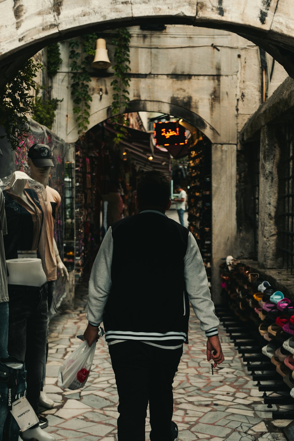 a man is walking down a narrow alley way