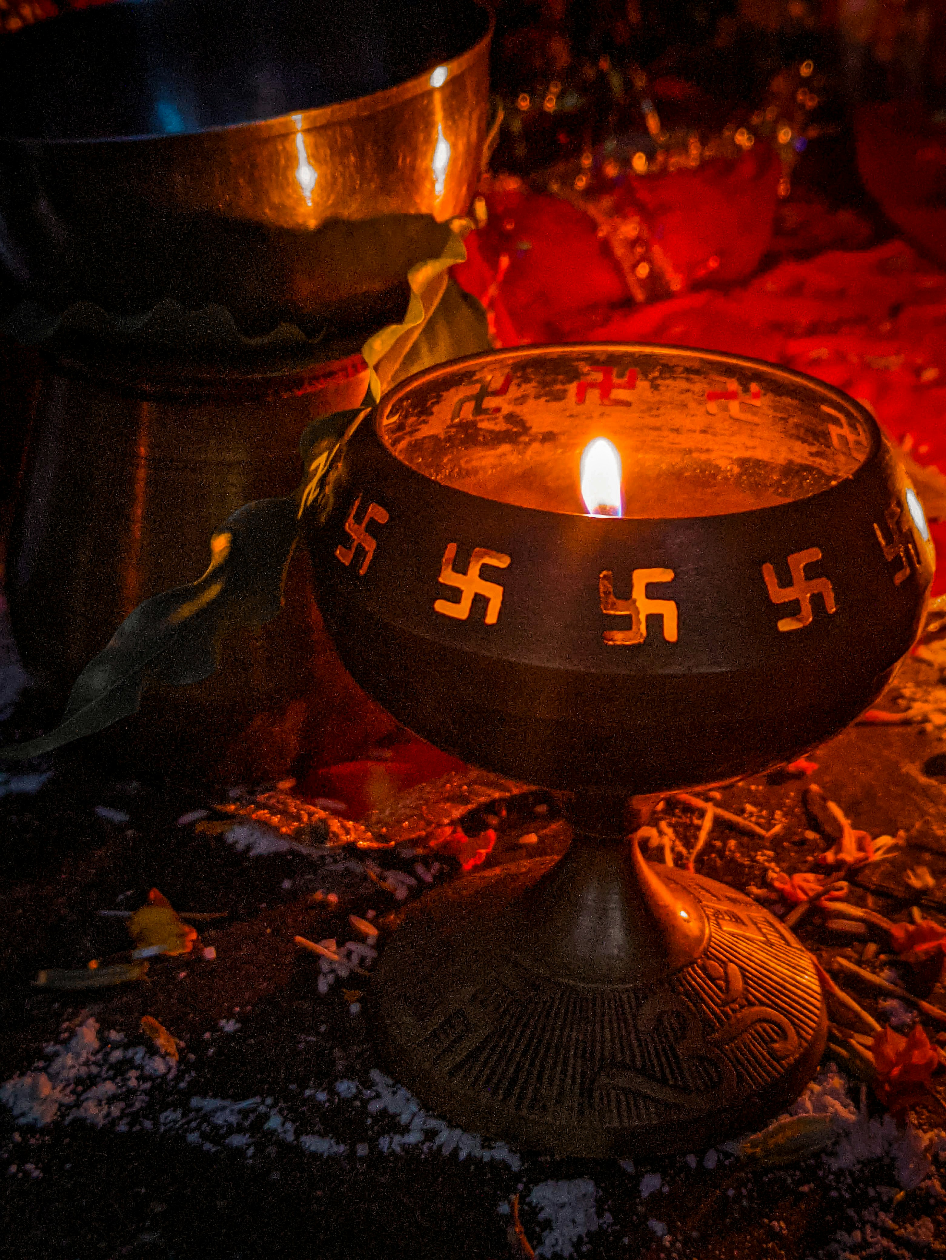 a lit candle sitting on top of a metal bowl