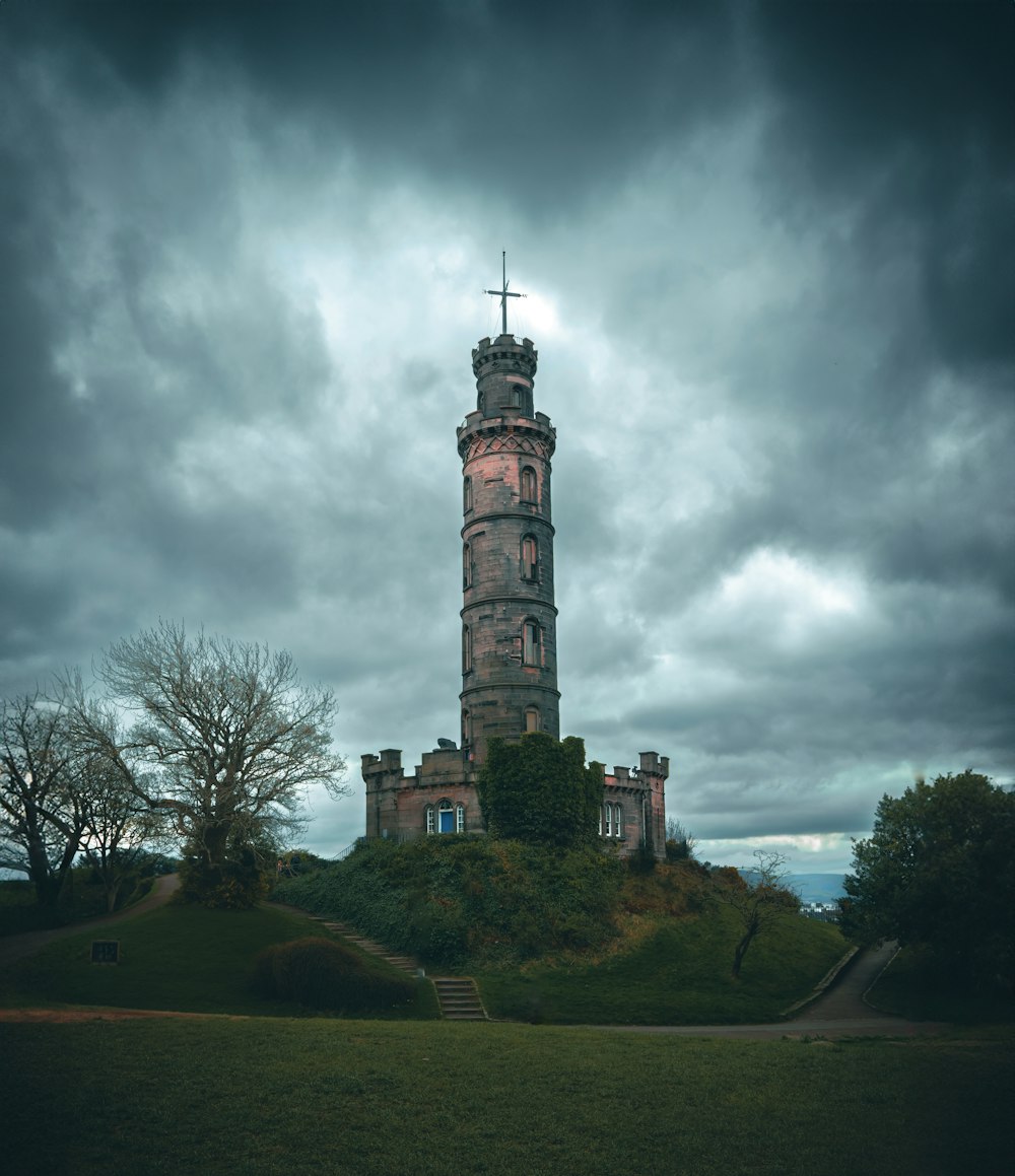 a tall tower sitting on top of a lush green hillside