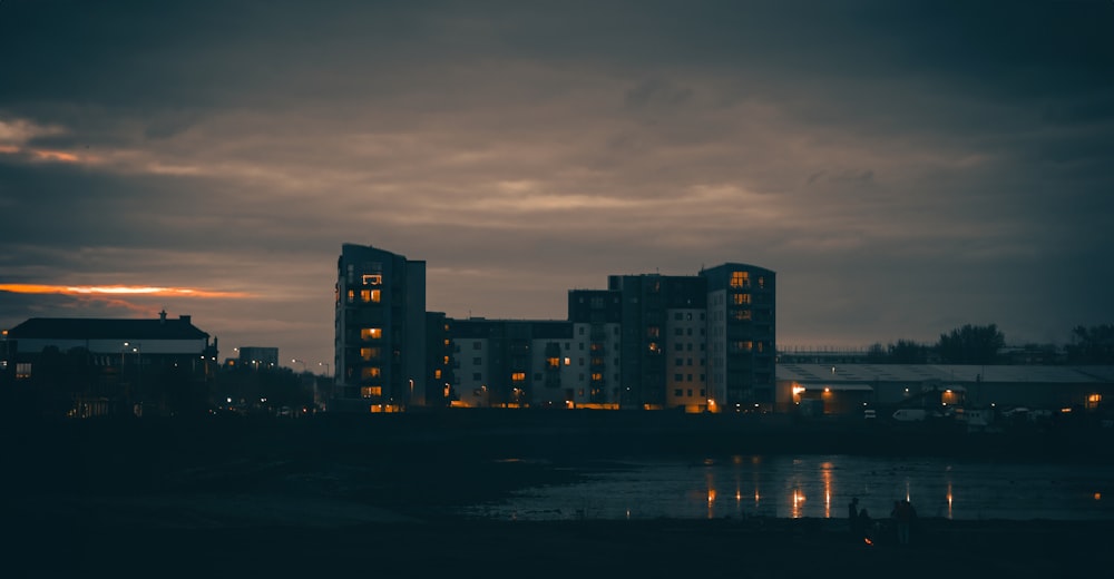 a city at night with a body of water in front of it