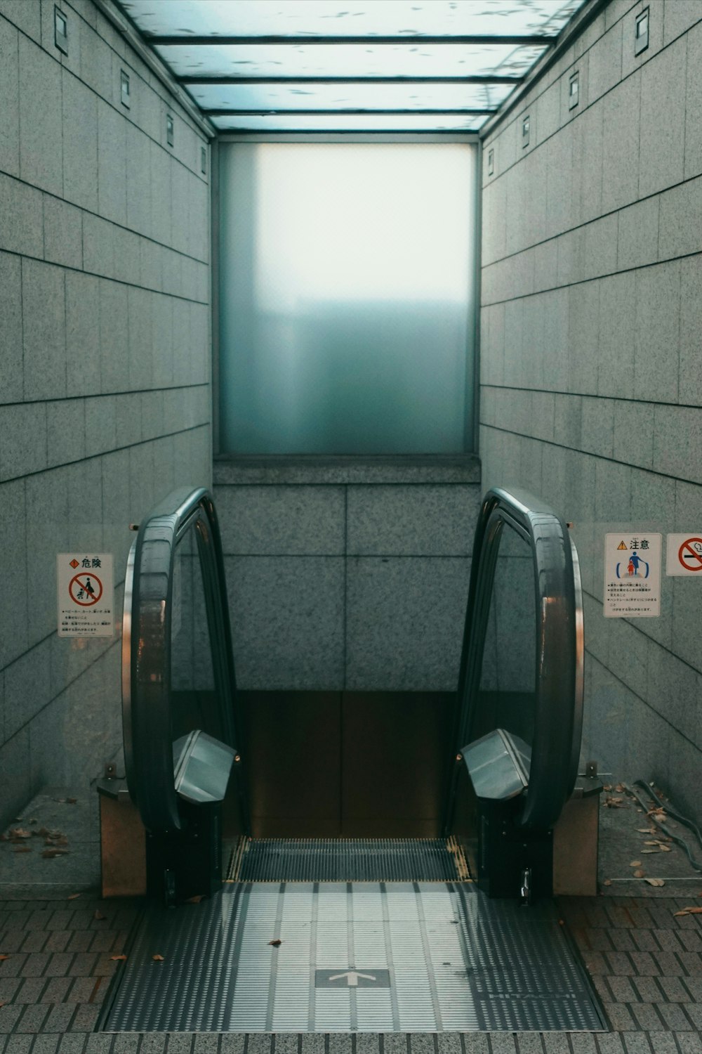 an escalator in a building with a screen above it