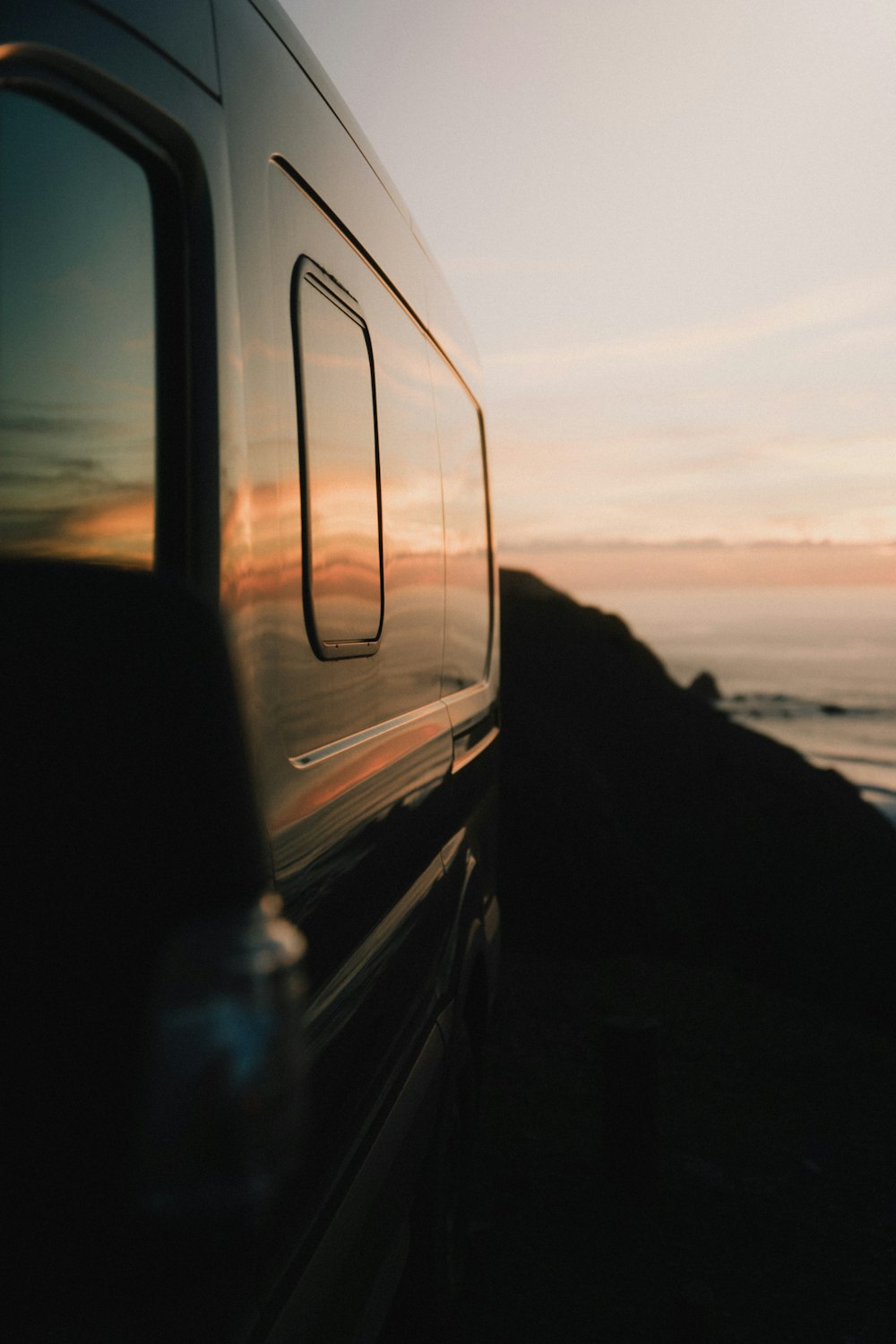 a van parked on the side of the road near the ocean