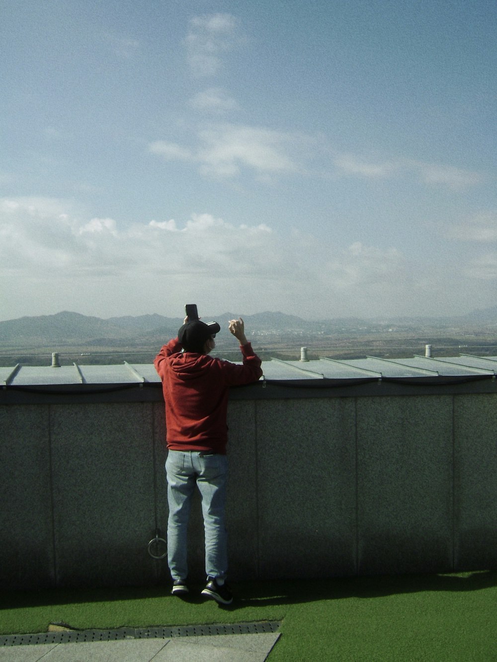 a man standing on top of a grass covered field