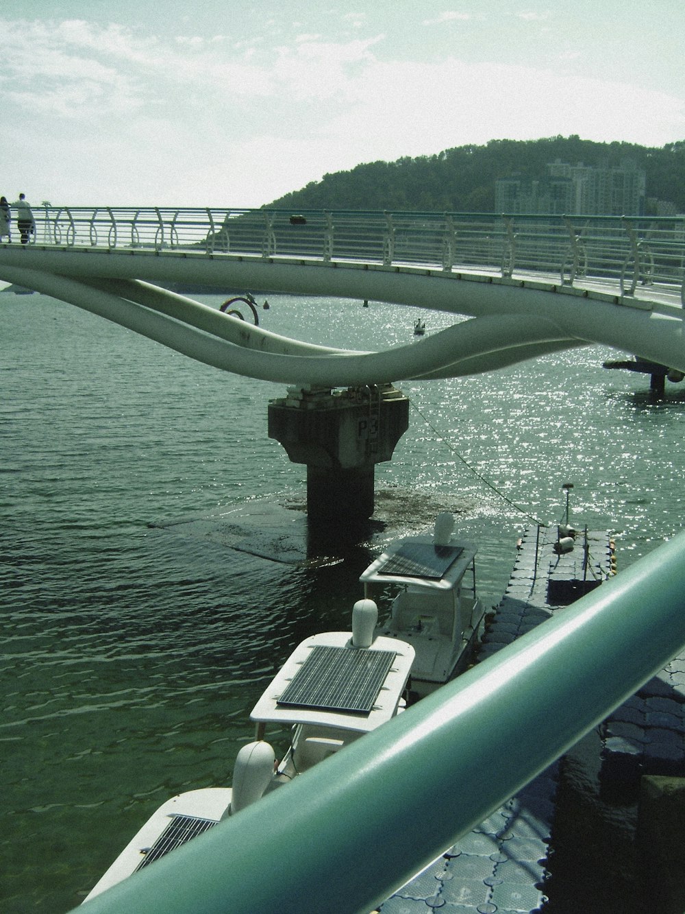 a boat traveling down a river next to a bridge