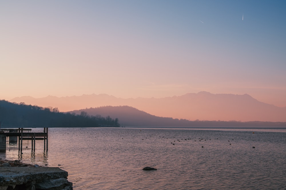 a body of water with mountains in the background