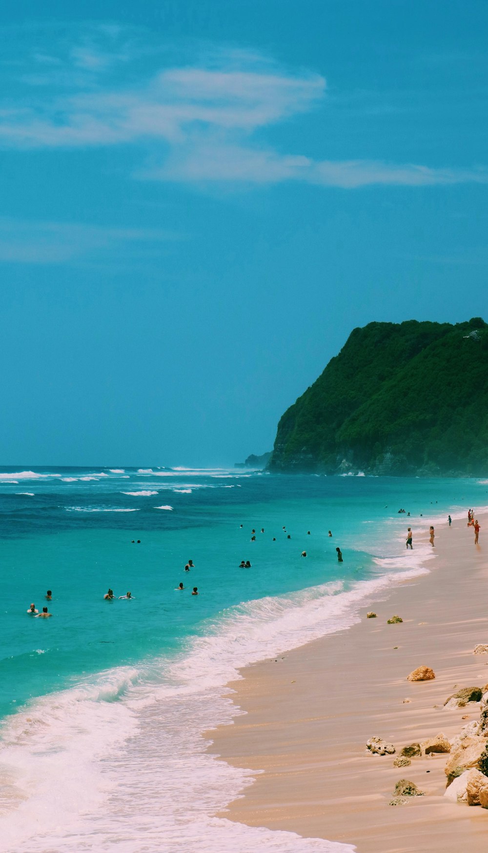 a group of people standing on top of a sandy beach