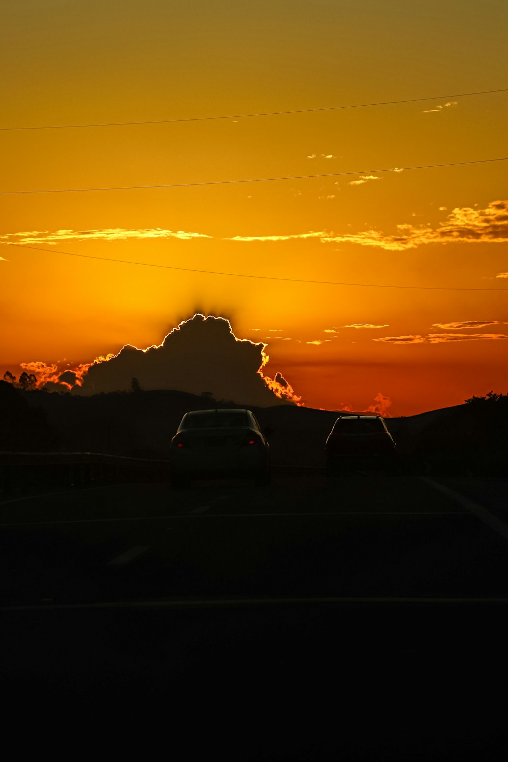 a car driving down a road at sunset